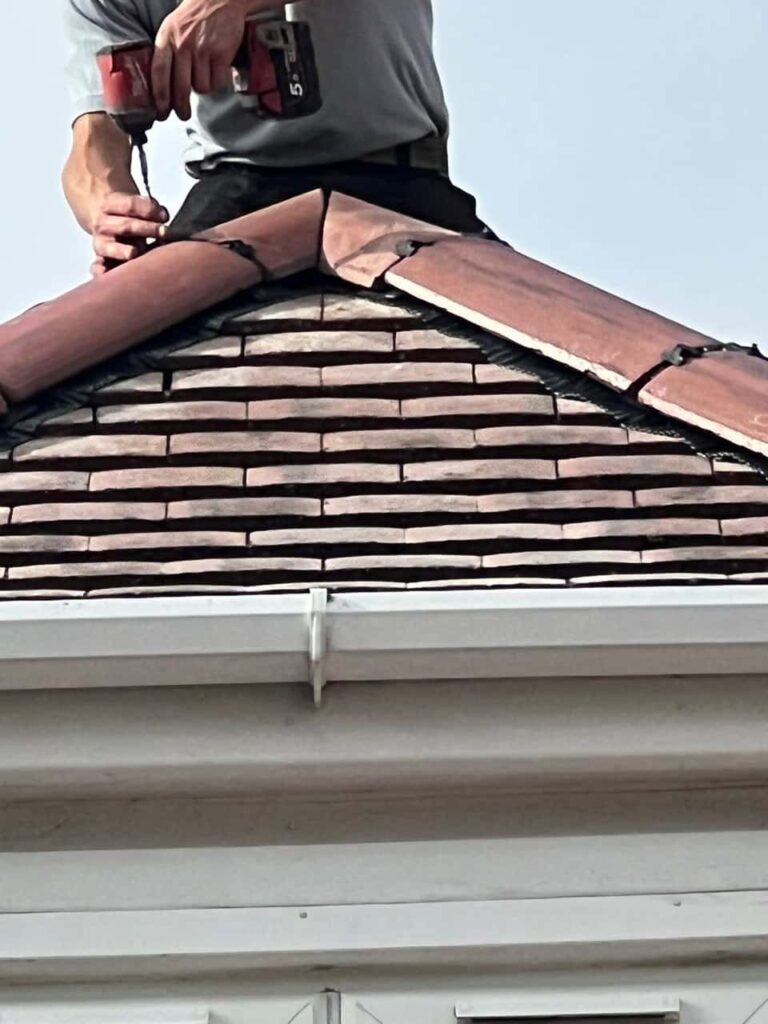 This is a photo of one of the operatives of Horley Roofing Repairs installing new ridge tiles